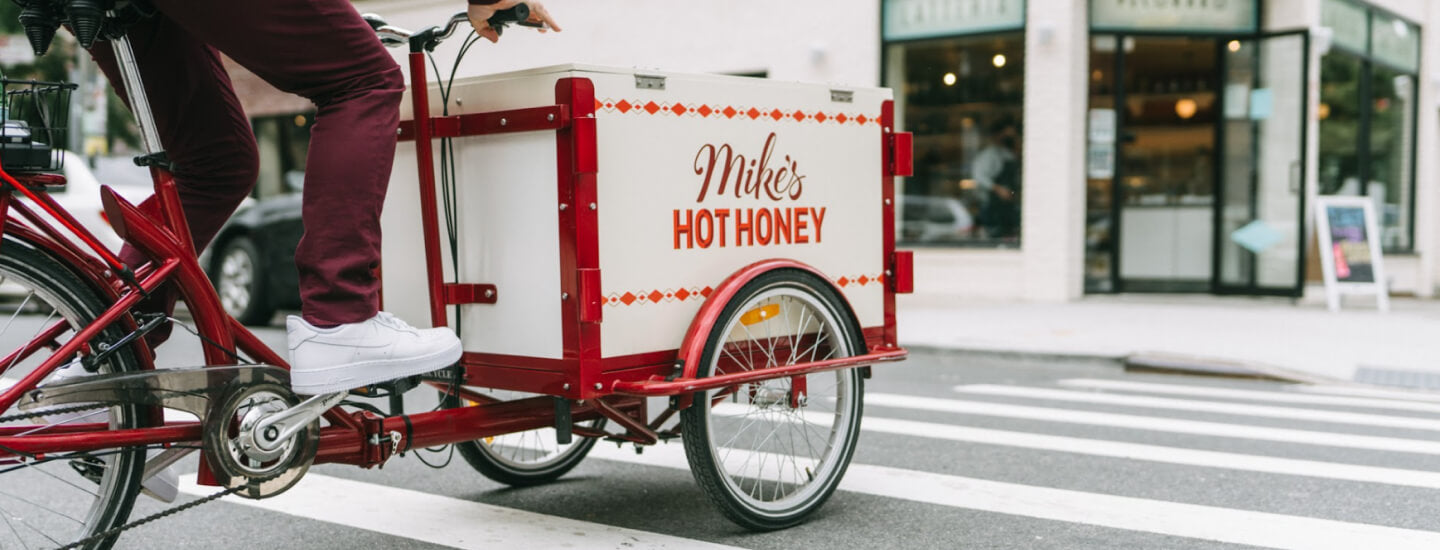 a person riding a bike with a cart